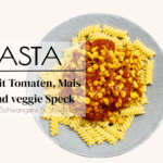 Tomaten Soße für Nudeln mit Mais und vegetarischen Speck angerichtet auf einem blauen Teller mit Spiralen Nudeln